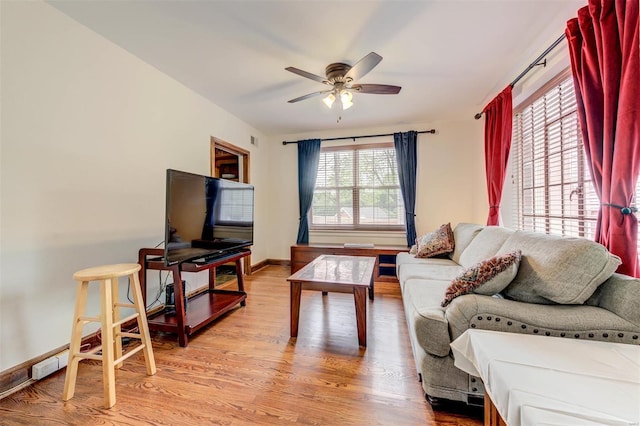 living area featuring wood finished floors, ceiling fan, and baseboards