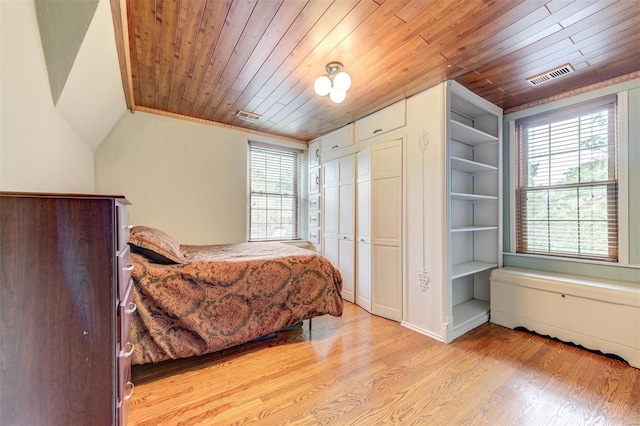 bedroom featuring wood ceiling, multiple windows, light wood finished floors, vaulted ceiling, and a closet