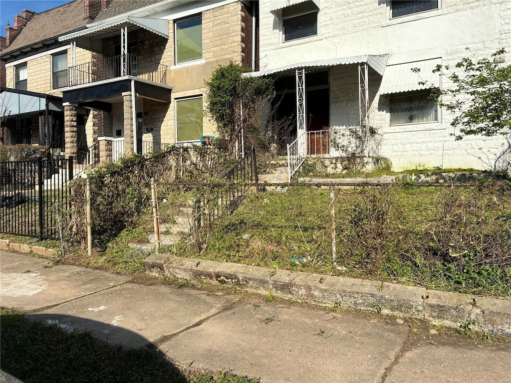 exterior space featuring stone siding and fence