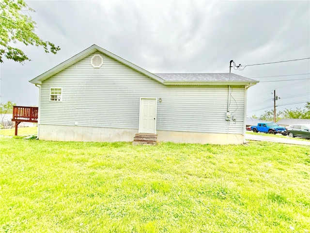 back of property featuring a lawn and a wooden deck