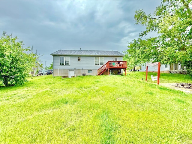 rear view of house featuring a deck, stairway, and a yard