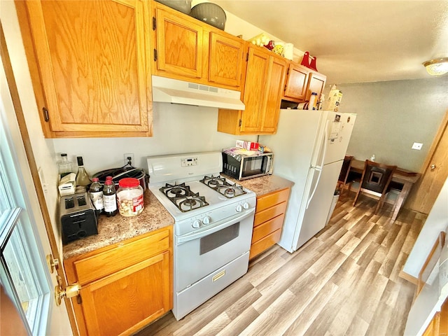 kitchen with white appliances, light wood-style flooring, and under cabinet range hood