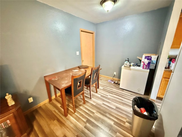 dining room featuring baseboards and light wood-style floors