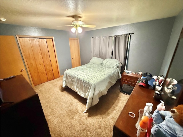 bedroom with a textured ceiling, a ceiling fan, a closet, and carpet