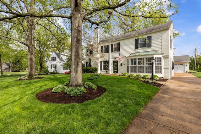view of front of house with a front lawn, a garage, concrete driveway, and a chimney