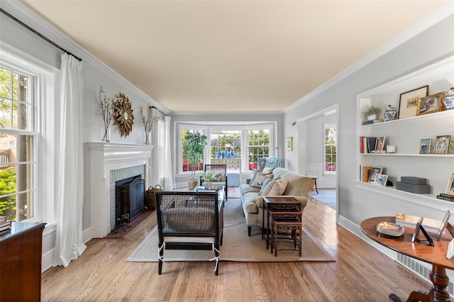 living room with wood finished floors, crown molding, and plenty of natural light