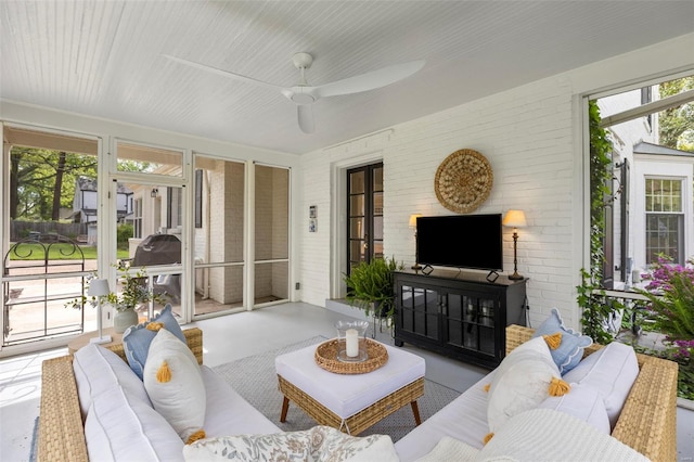 sunroom featuring a ceiling fan and an outdoor hangout area