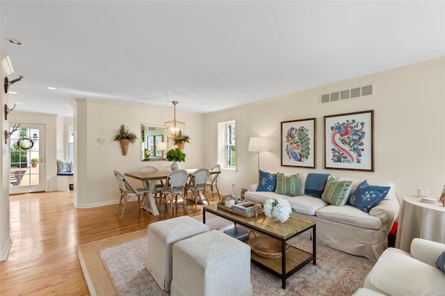 living area with visible vents, a healthy amount of sunlight, baseboards, and light wood-style floors