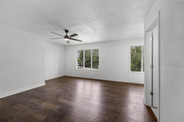 unfurnished room with ceiling fan, a textured ceiling, baseboards, a textured wall, and dark wood-type flooring