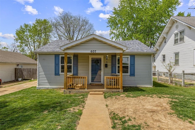 bungalow with a porch, a shingled roof, and a front yard