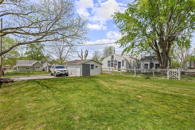 view of yard with fence and an outbuilding