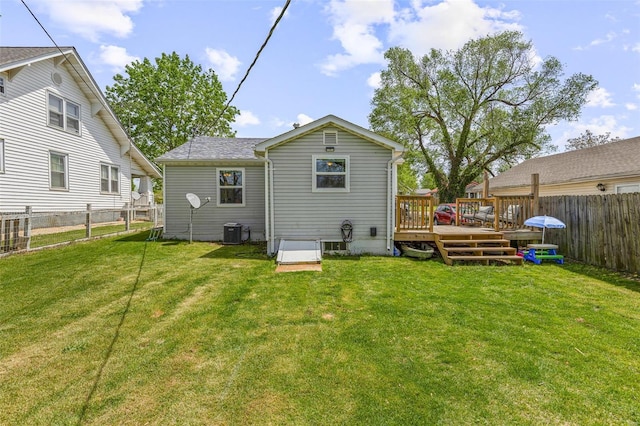 back of house featuring a wooden deck, central AC unit, a fenced backyard, and a yard