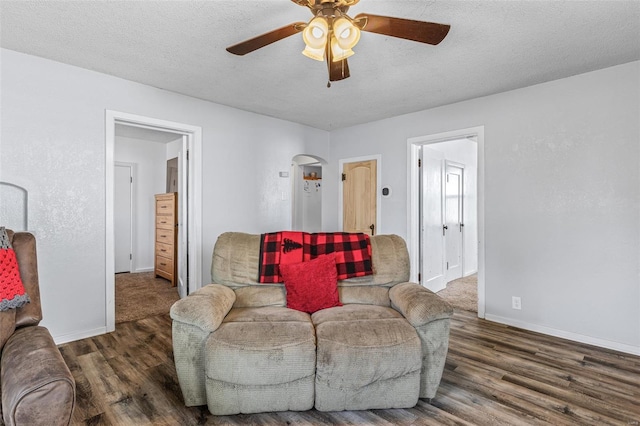 living area featuring baseboards, wood finished floors, and a ceiling fan