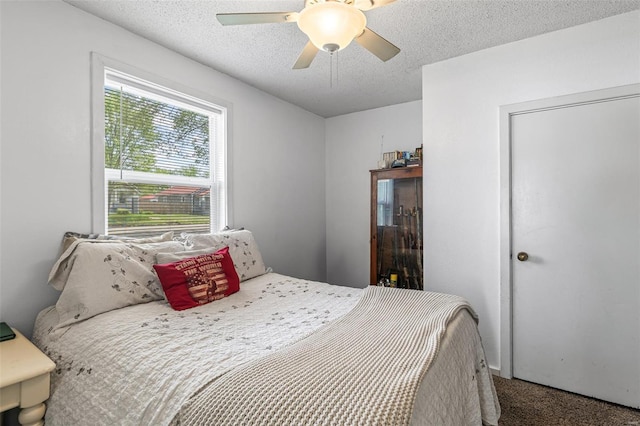 bedroom with carpet, ceiling fan, and a textured ceiling
