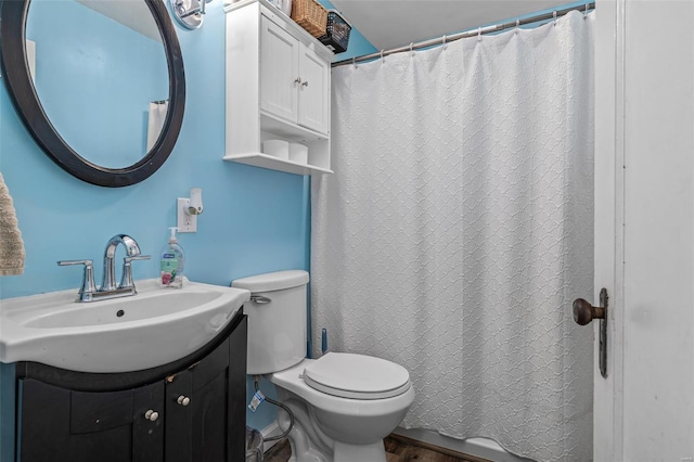 full bathroom featuring a shower with shower curtain, toilet, wood finished floors, and vanity