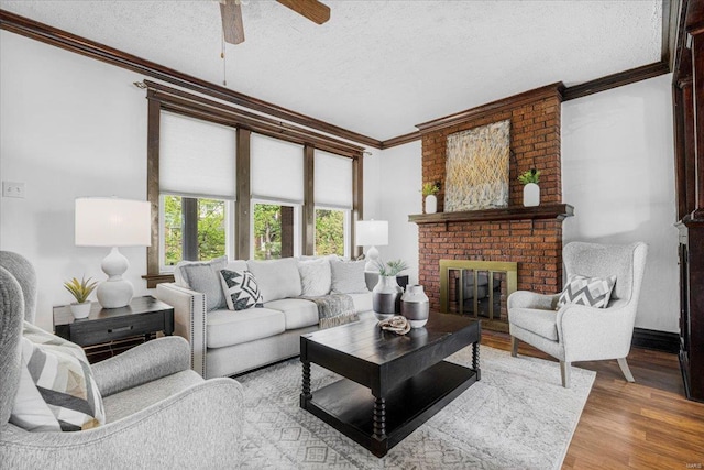 living room featuring crown molding, a textured ceiling, a ceiling fan, and wood finished floors