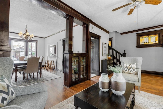 living area with crown molding, a textured ceiling, and wood finished floors