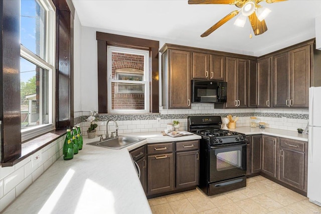 kitchen with light countertops, a sink, black appliances, and tasteful backsplash