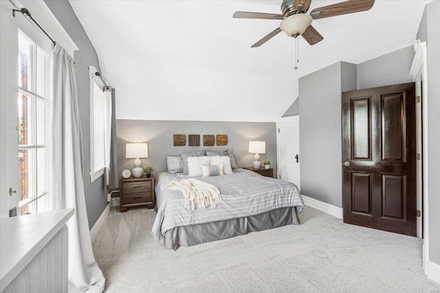 bedroom with baseboards, carpet, lofted ceiling, and multiple windows
