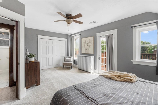 carpeted bedroom featuring access to outside, ceiling fan, radiator, visible vents, and a closet