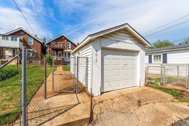 detached garage with a gate and fence