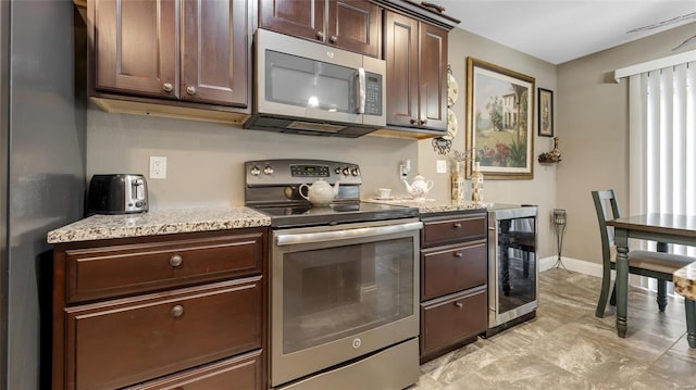 kitchen featuring wine cooler, stainless steel appliances, dark brown cabinets, and baseboards