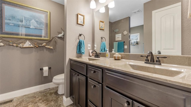 bathroom featuring toilet, a sink, baseboards, and visible vents