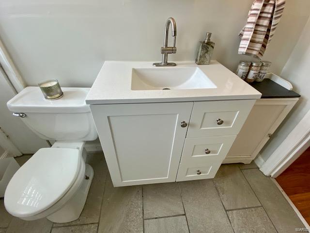 half bathroom featuring toilet and vanity