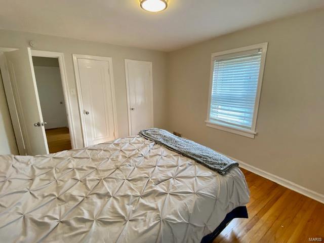 bedroom with wood finished floors and baseboards