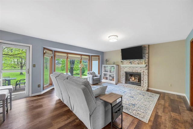 living area featuring baseboards, a healthy amount of sunlight, and dark wood-type flooring