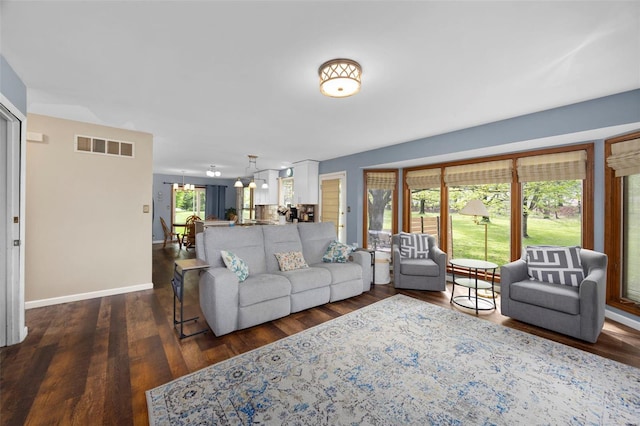 living area with wood finished floors, visible vents, and baseboards