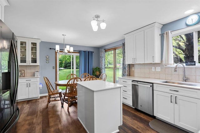 kitchen featuring light countertops, dishwasher, black refrigerator with ice dispenser, a sink, and a notable chandelier