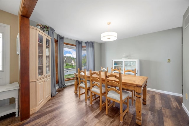 dining area with dark wood-style flooring and baseboards