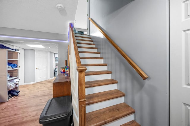 stairs featuring wood finished floors and baseboards