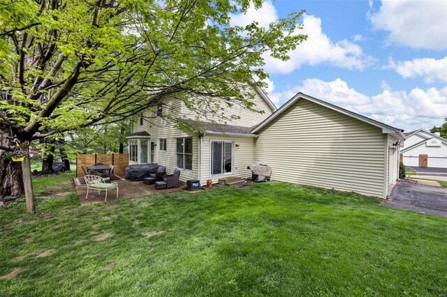 rear view of property featuring a yard, entry steps, a patio, and an outdoor hangout area