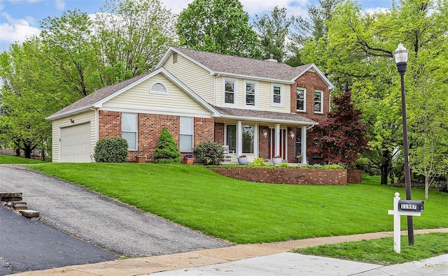 traditional-style home with a front lawn, a shingled roof, an attached garage, and brick siding