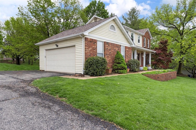 view of front of house featuring a front lawn, driveway, an attached garage, and roof with shingles