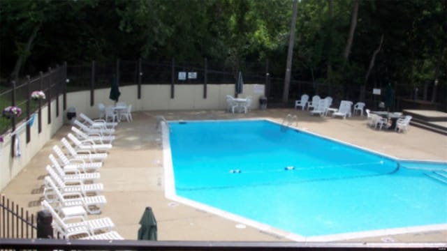 pool featuring fence and a patio area