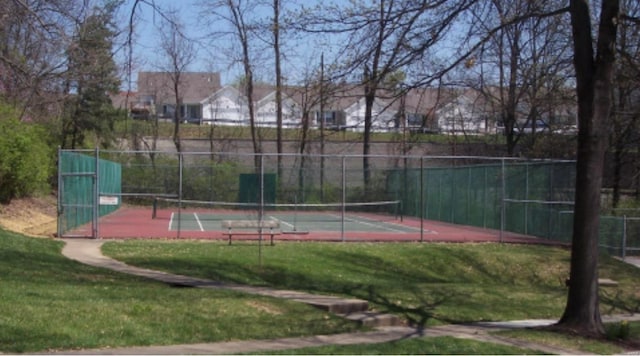 view of sport court with fence and a yard