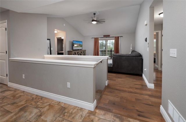 hall featuring visible vents, lofted ceiling, and baseboards