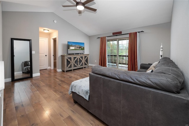 living area with baseboards, hardwood / wood-style flooring, a ceiling fan, and lofted ceiling