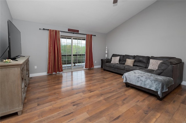 living room featuring ceiling fan, vaulted ceiling, wood finished floors, and baseboards