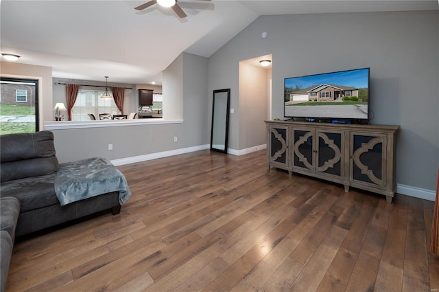 living area featuring hardwood / wood-style floors, baseboards, ceiling fan, and lofted ceiling
