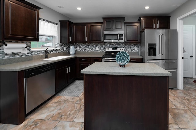 kitchen with a sink, stainless steel appliances, dark brown cabinets, a kitchen island, and backsplash
