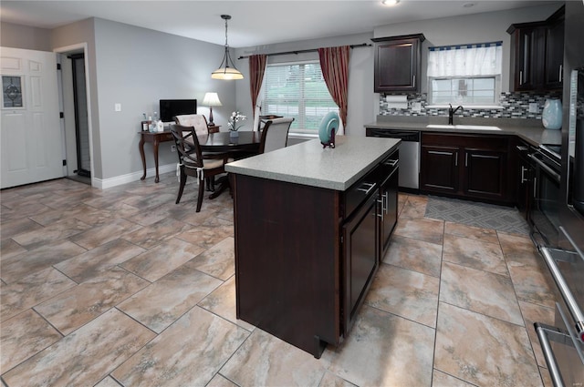 kitchen with a sink, decorative backsplash, light countertops, baseboards, and dishwasher