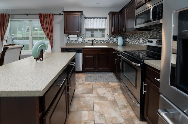 kitchen with a sink, a wealth of natural light, stainless steel appliances, and decorative backsplash