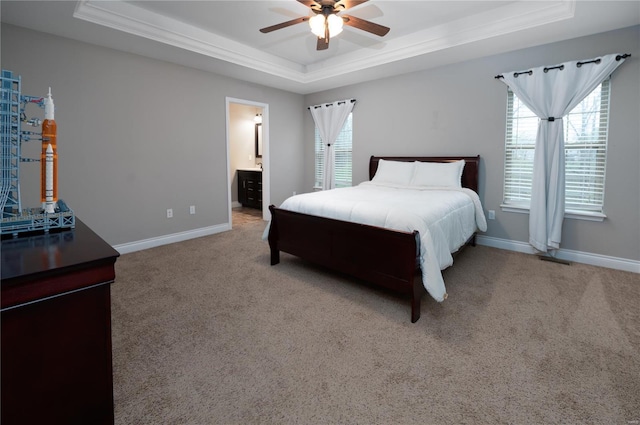 bedroom featuring crown molding, a raised ceiling, carpet floors, baseboards, and a ceiling fan
