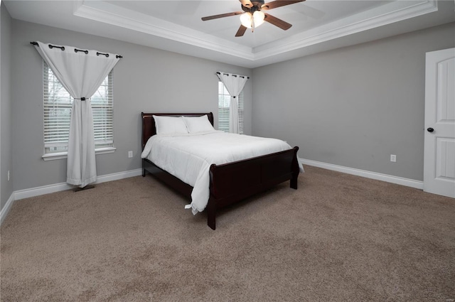 bedroom with baseboards, ornamental molding, carpet floors, and a tray ceiling