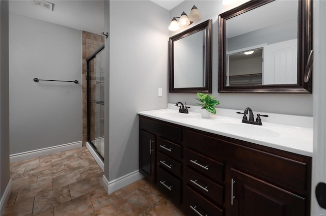 full bathroom featuring visible vents, a sink, a shower stall, and baseboards