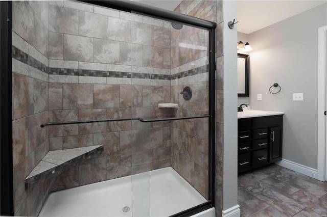 bathroom with vanity, a shower stall, and baseboards